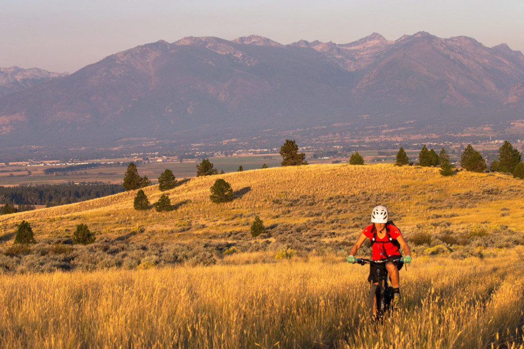 woman mountain biking with Montana's bitterroot mountains in background