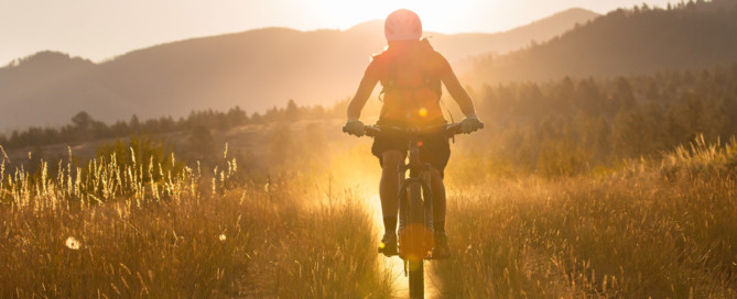 woman mountain biking in morning sun in bitterroot valley montana