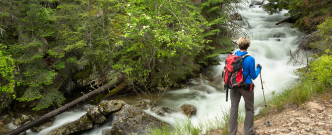 woman hiking with water cascading