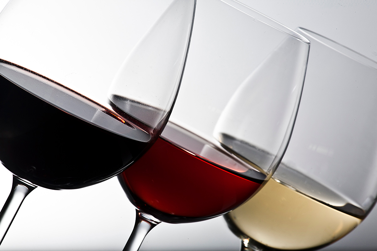 three wine glasses with red wine, white wine